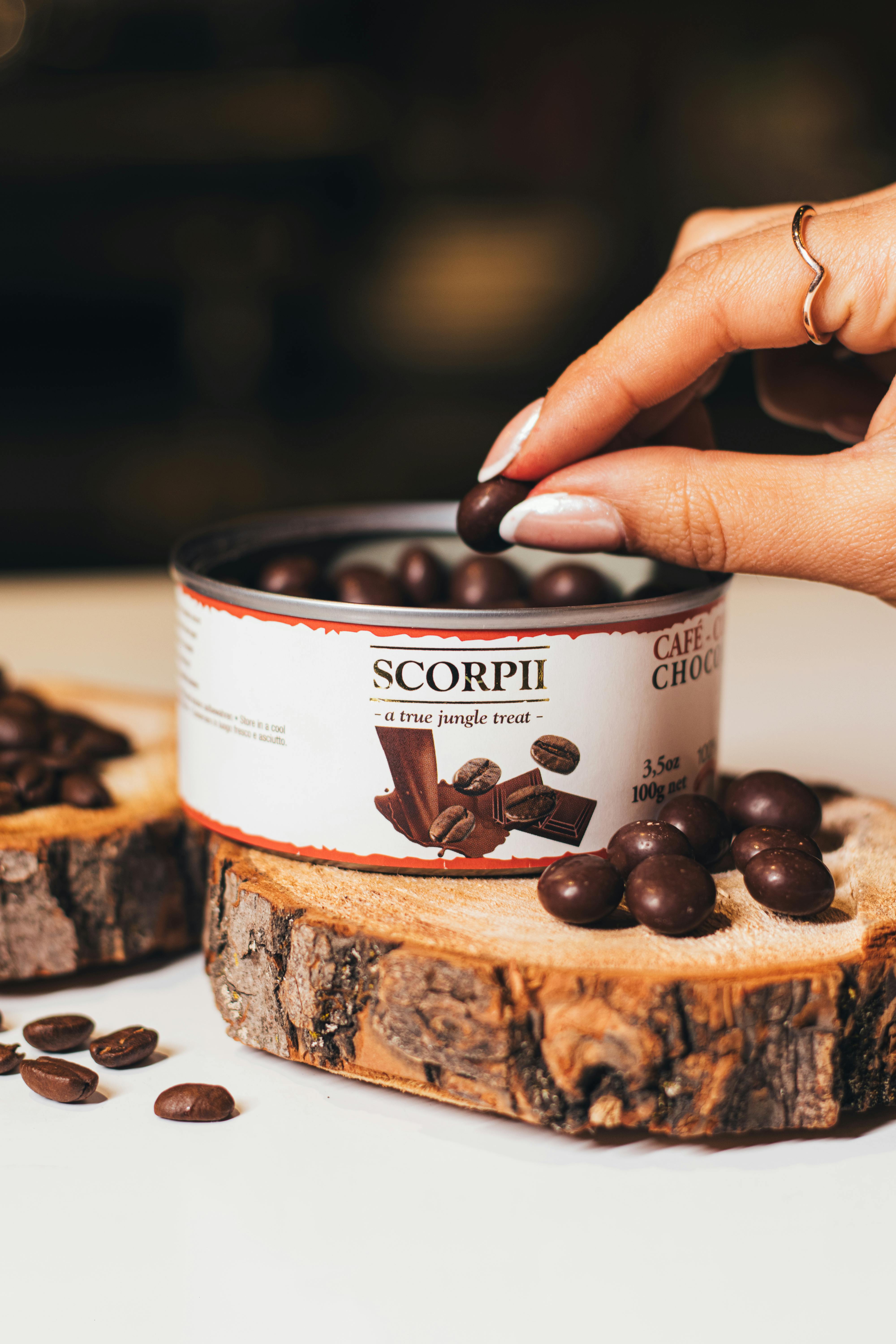 Chocolate-covered coffee beans setting on parchment in a single layer