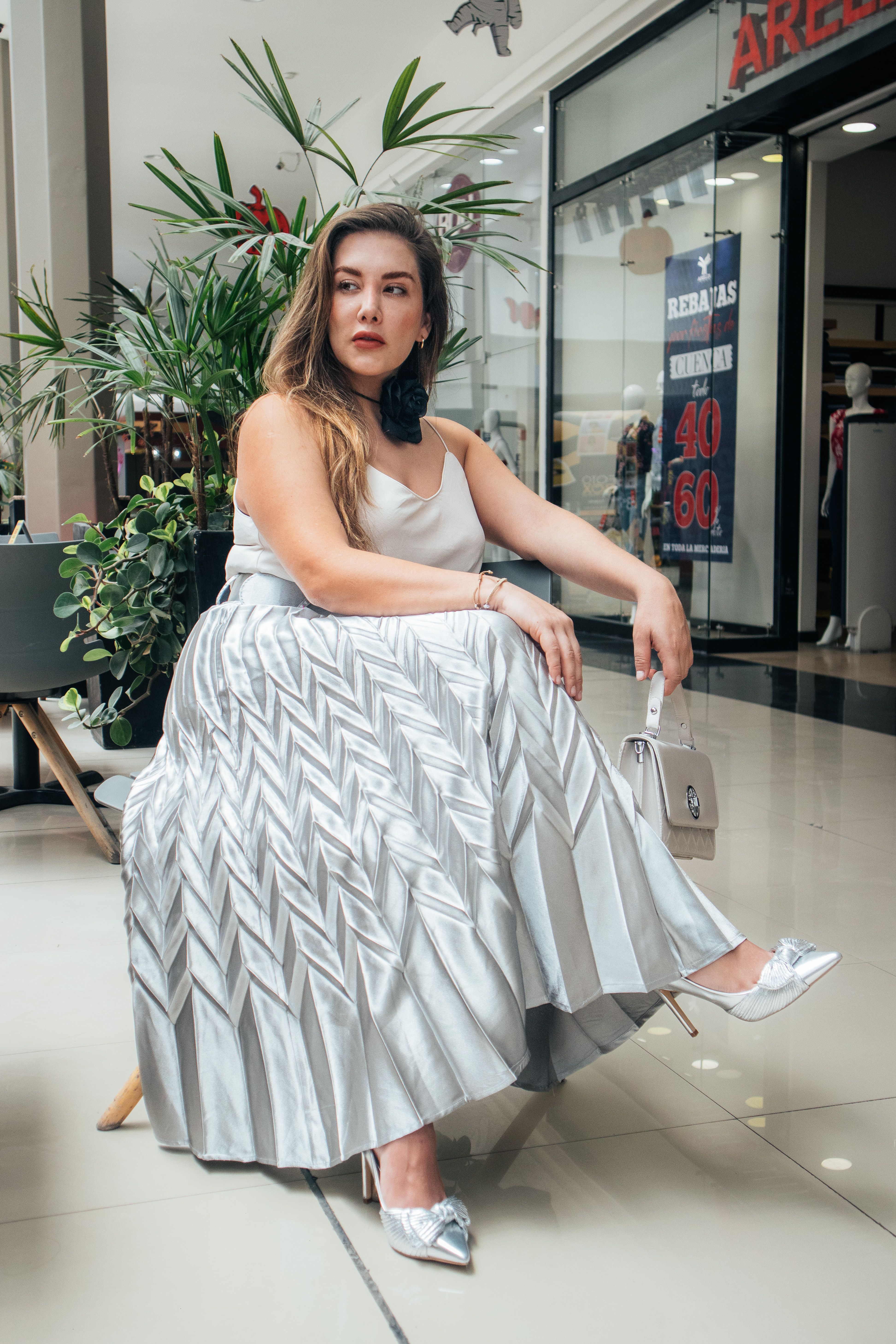 Woman in pleated satin midi skirt with turtleneck