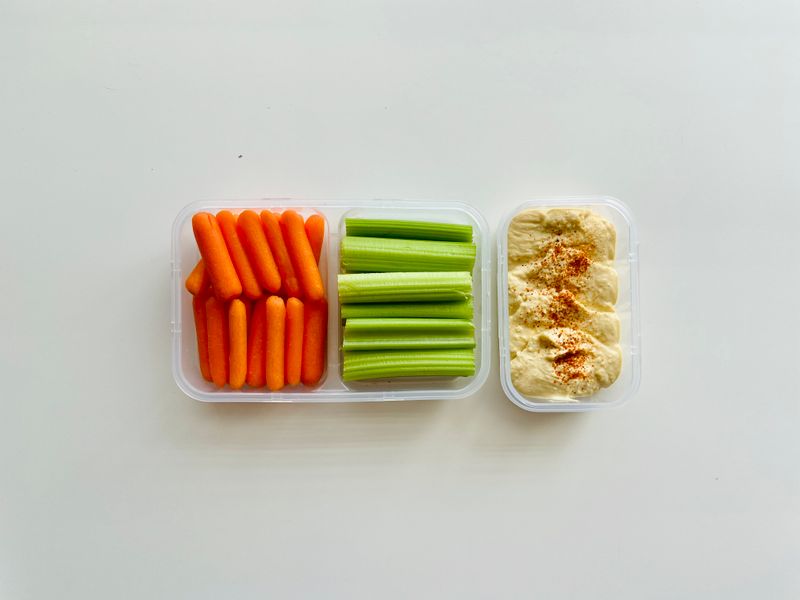cucumber slices and hummus in a small container