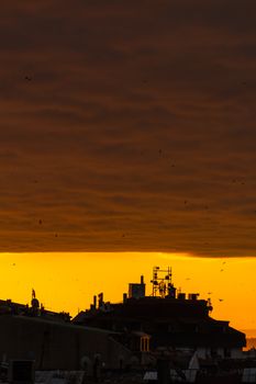 Stunning urban skyline silhouette against a vibrant sunset sky in Istanbul.