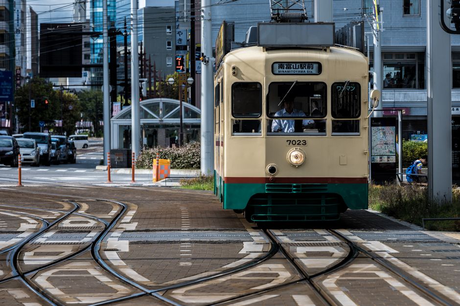 Vintage tram on tracks in Toyama City, Japan, showcasing urban life.