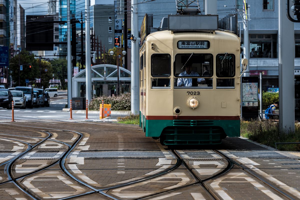 Toyama city tram on the street in daylight — the compact urban transit network the city is known for