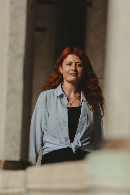 Free A red-haired woman stands confidently in a sunlit architectural setting in Istanbul, Türkiye. Stock Photo