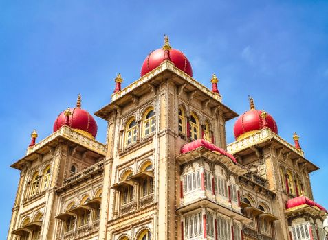 A view of the stunning Mysore Palace architecture with vibrant red domes and intricate details in India.