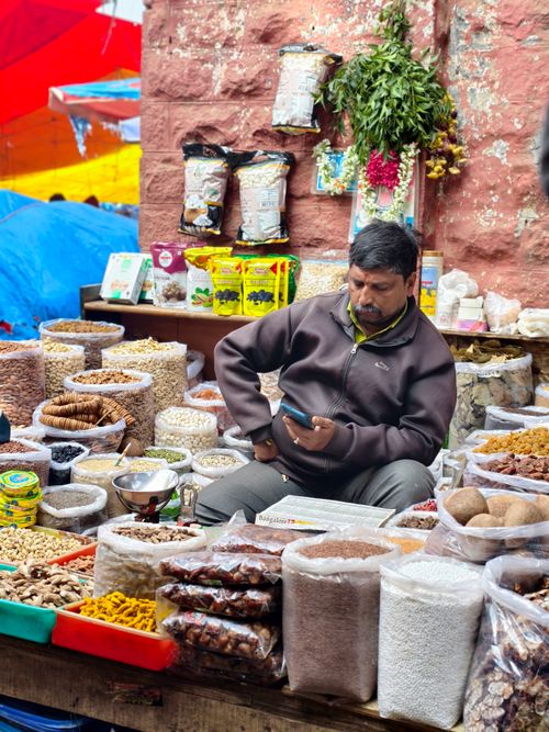 Free Colorful local market with a vendor selling a variety of spices and nuts. Stock Photo
