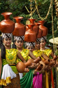 Women in traditional attire perform a cultural dance with pottery outdoors. - Fotografer Sidoarjo