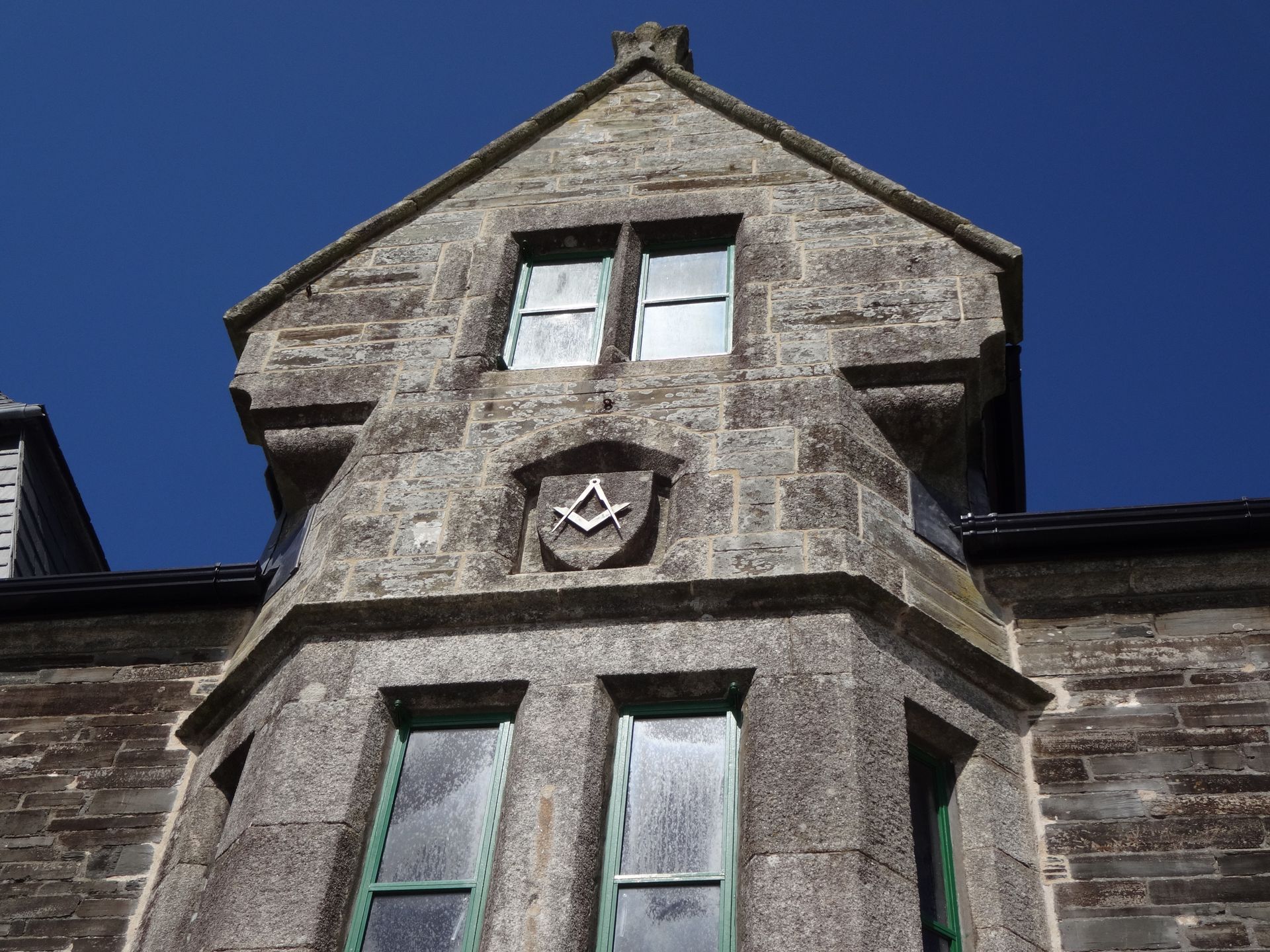 Historic stone building with Masonic symbols carved in facade