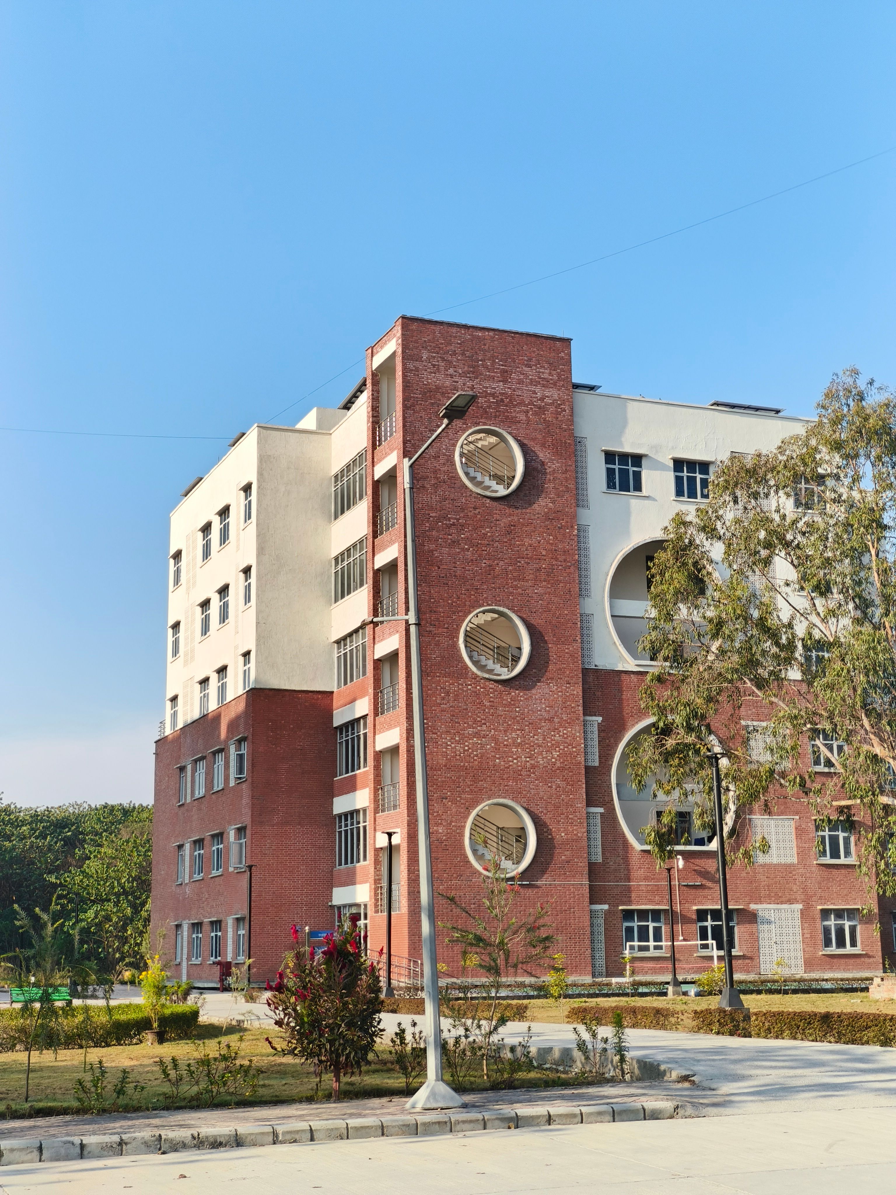 Brick educational building with circular design elements on a sunny day.
