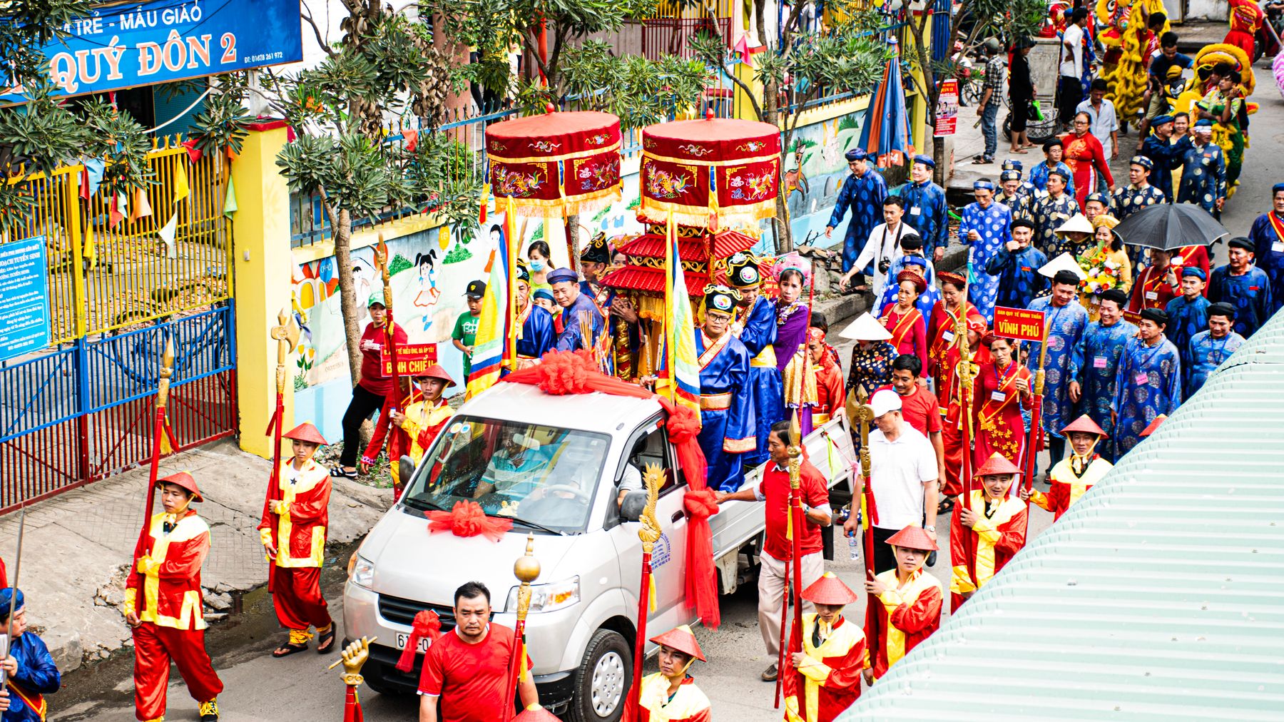 Vibrant parade with traditional attire in Thuận An, Vietnam, celebrating cultural heritage.