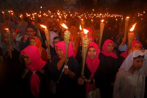 Free A vibrant torchlight procession at night featuring women in traditional attire, celebrating in Bandung, Indonesia. Stock Photo