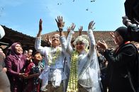 Traditional Sundanese wedding in Bandung, West Java, featuring happy couple and guests celebrating outdoors.