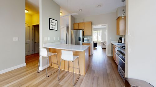 Free Spacious modern kitchen with island, sleek cabinets, and natural lighting. Stock Photo