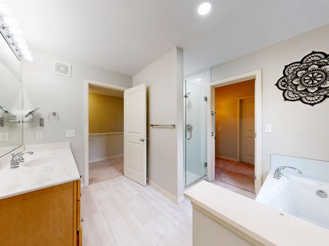 Bright and modern bathroom with large vanity and shower, featuring ample natural light and elegant decor.