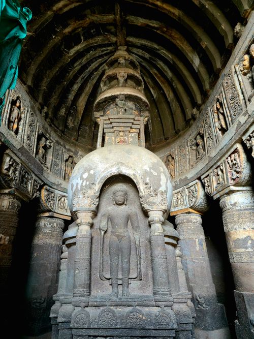 Free Explore the intricate carvings of an ancient rock-cut Buddhist temple with a statue. Stock Photo