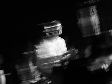 Blurry black and white artistic shot of musician in motion, evoking movement.