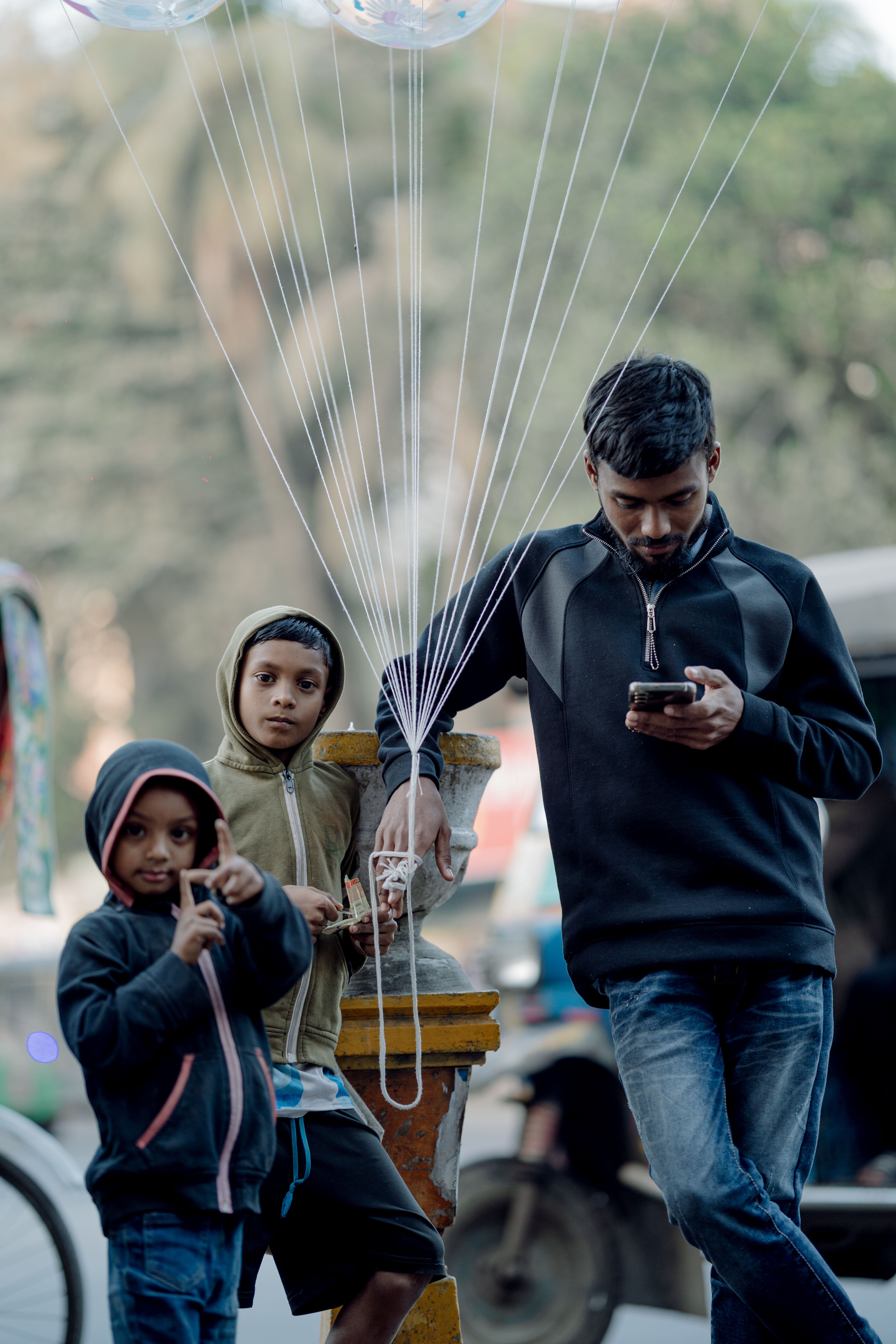 Ye toh har shaam ka nazaara hai 🌅! Balloon wala bhaiya phone mein busy aur bachche dekh rahe hain unhein 📱🎈 #dailyLifeInMumbai #tolee #balloonSellers