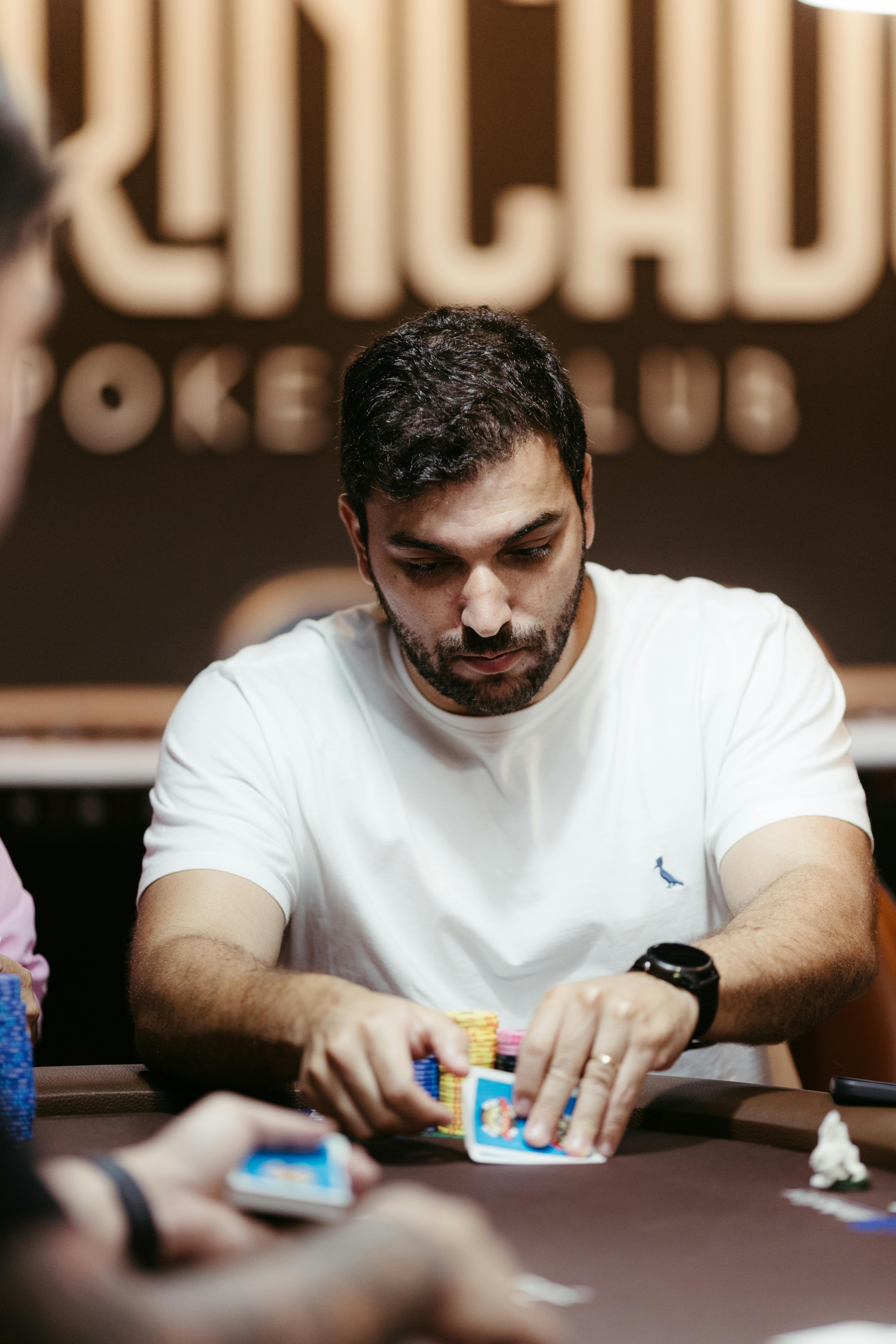 Focused poker player managing chips at a poker club table.