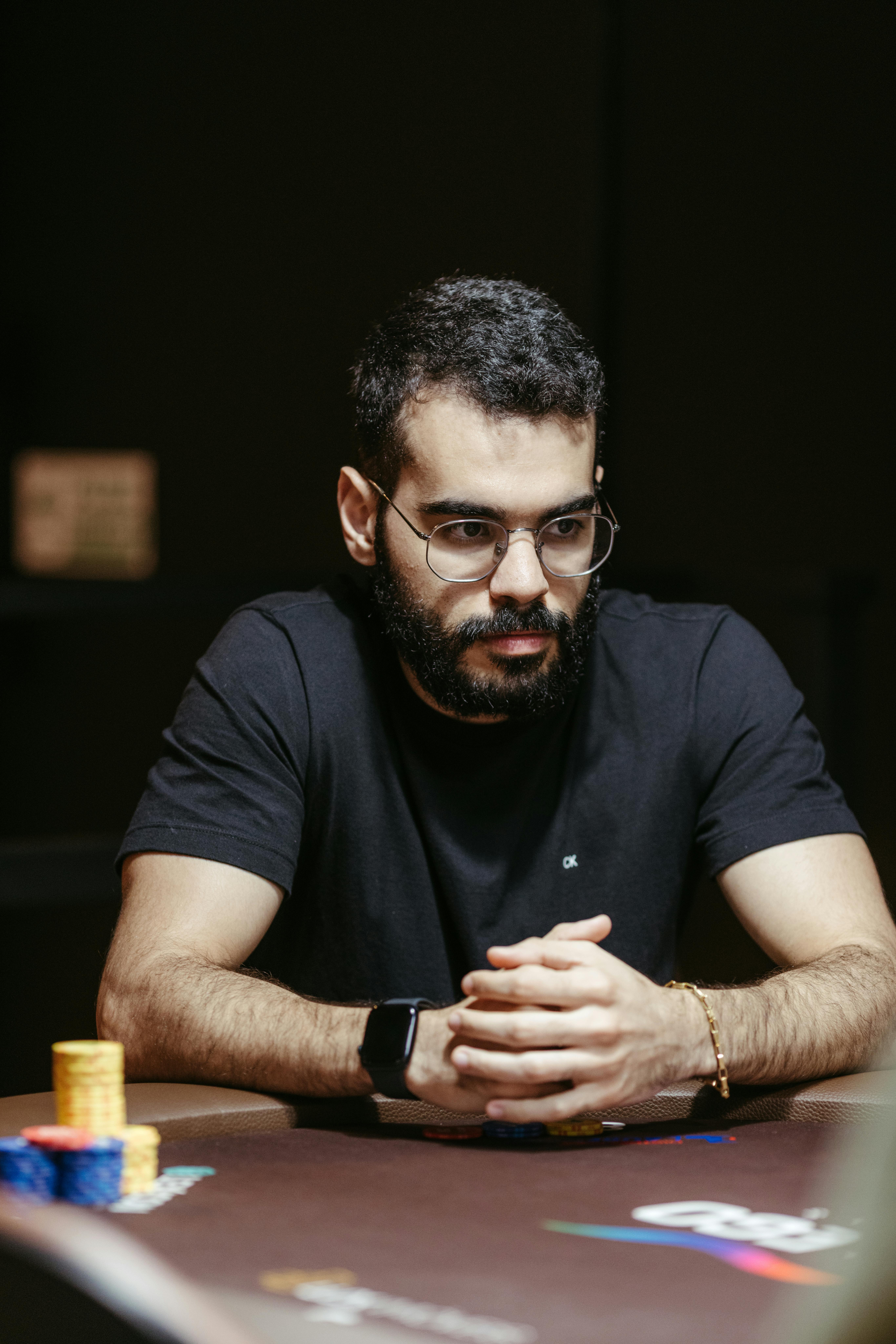 A focused poker player strategizing during a high-stakes tournament.