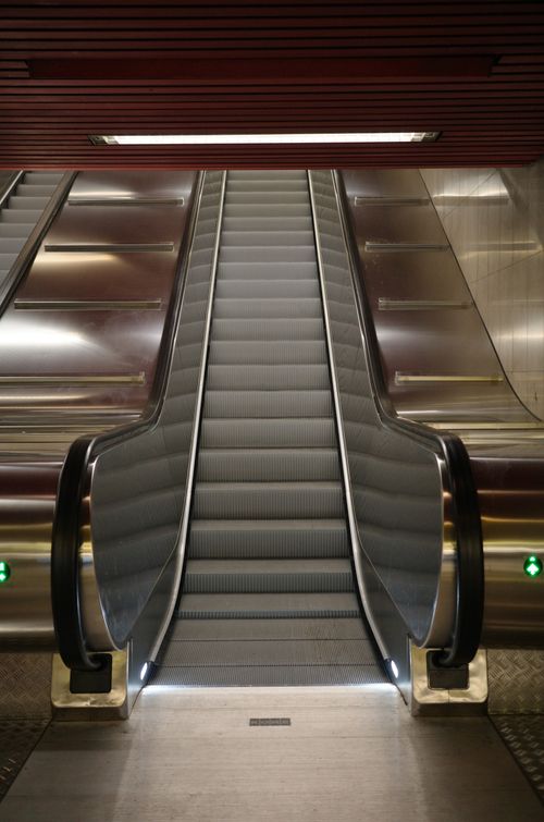 Free Empty subway escalator with modern design and metallic surfaces indoors, ideal for travel-related content. Stock Photo
