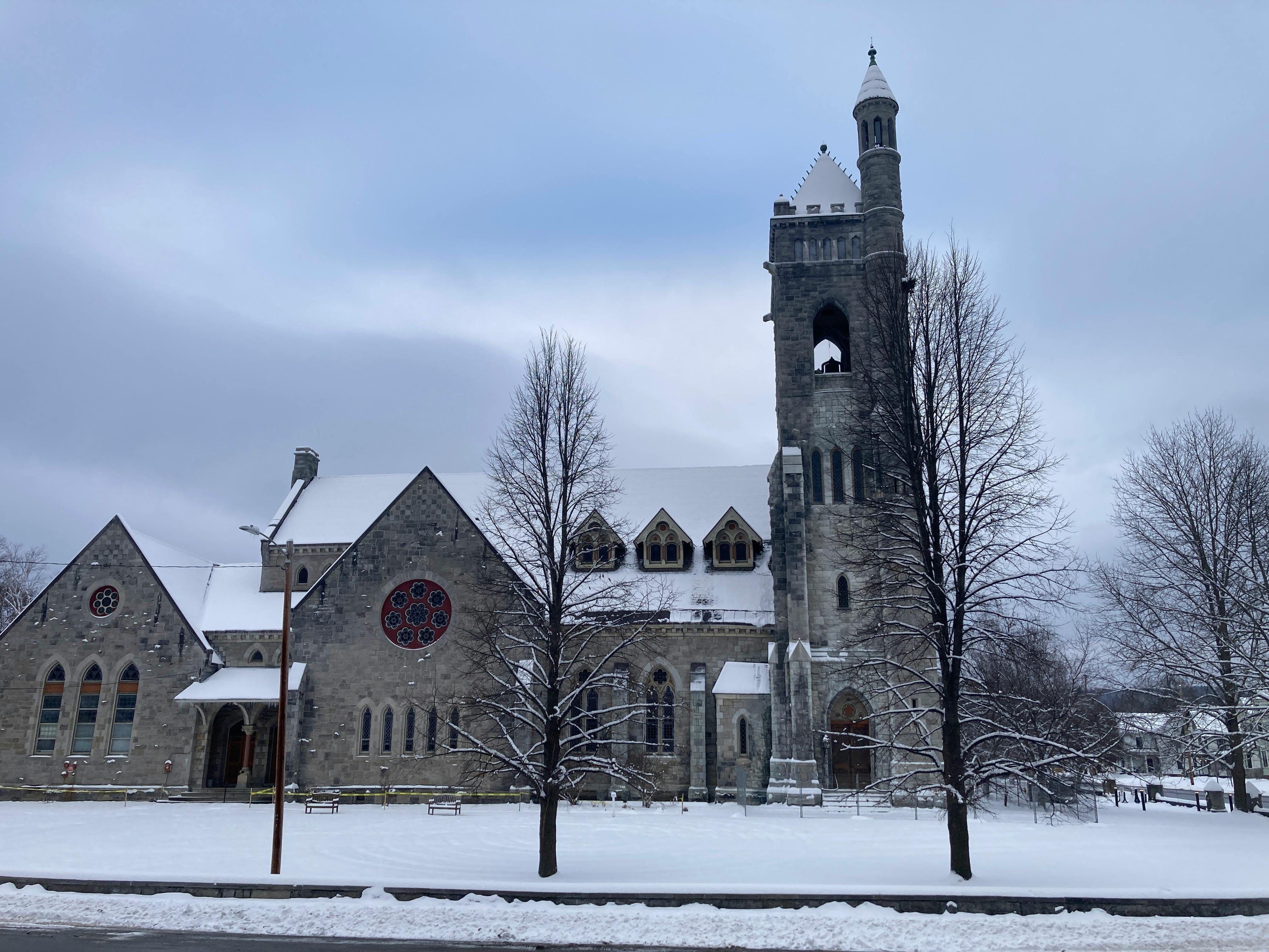 A historic church surrounded by snow in a serene winter setting in St. Johnsbury, Vermont.