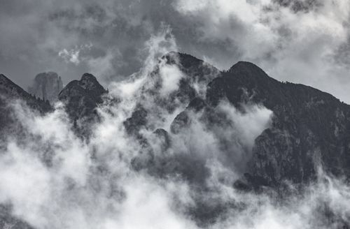 Free Stunning monochrome view of misty mountains with dramatic clouds enveloping the peaks. Stock Photo