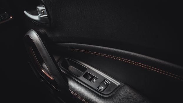 Detailed view of a car door interior showcasing handle and stitching.