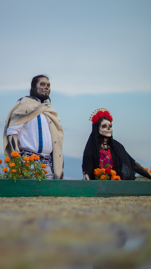 Free Couple dressed in traditional Day of the Dead attire with face paint and marigold flowers. Stock Photo
