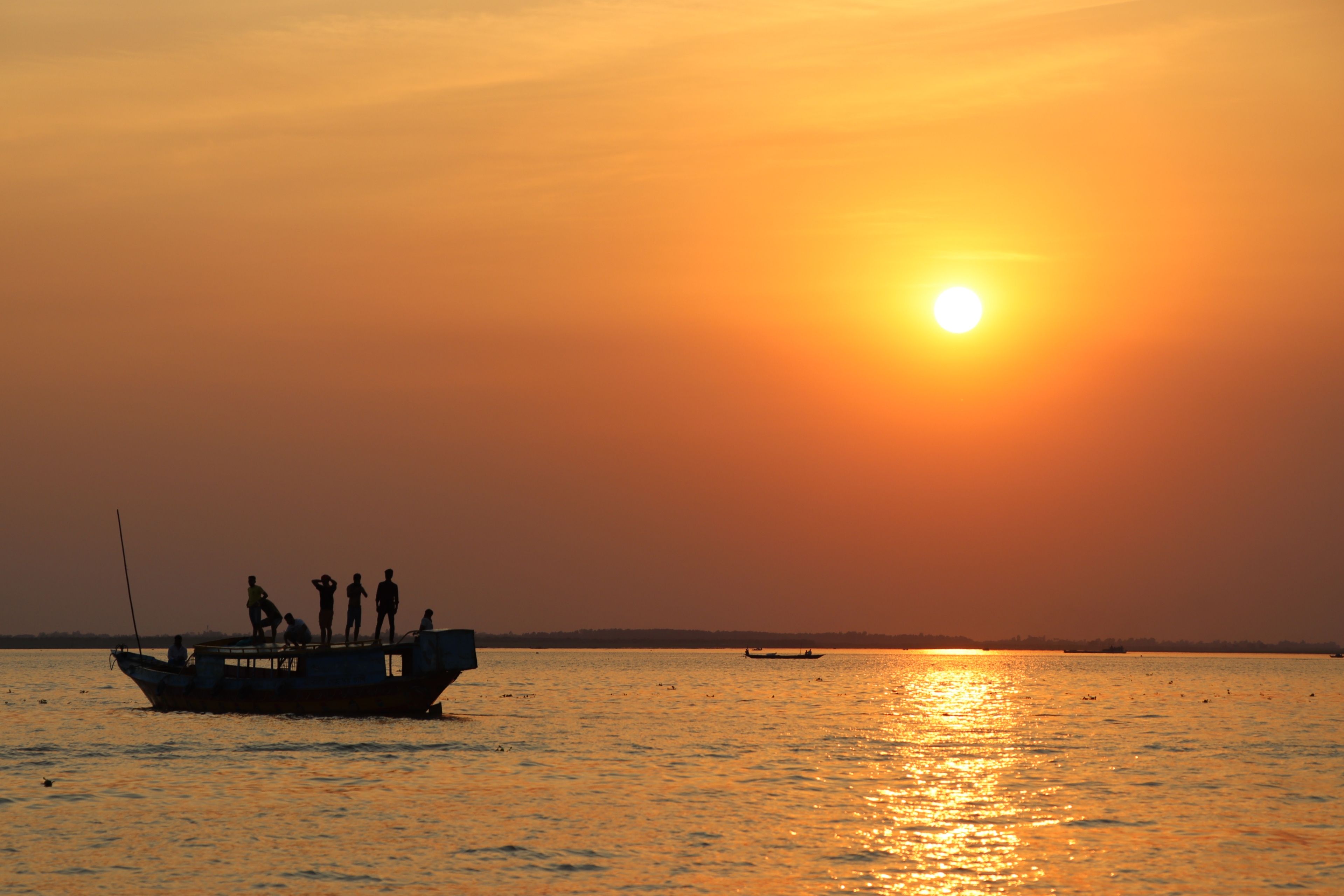 Silhouetted Boat at Sunset on Calm Waters · Free Stock Photo