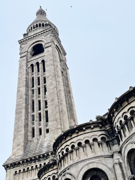 Upward view of Sacré-Cœur Basilica's tower in crisp daylight.
