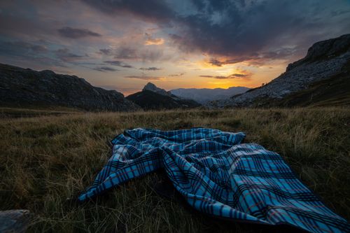 Free Tranquil mountain landscape at sunset with a plaid blanket, showcasing nature's vibrant colors. Stock Photo