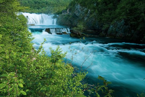 Free Majestic waterfall flowing through a lush green landscape, evoking serenity and natural beauty. Stock Photo