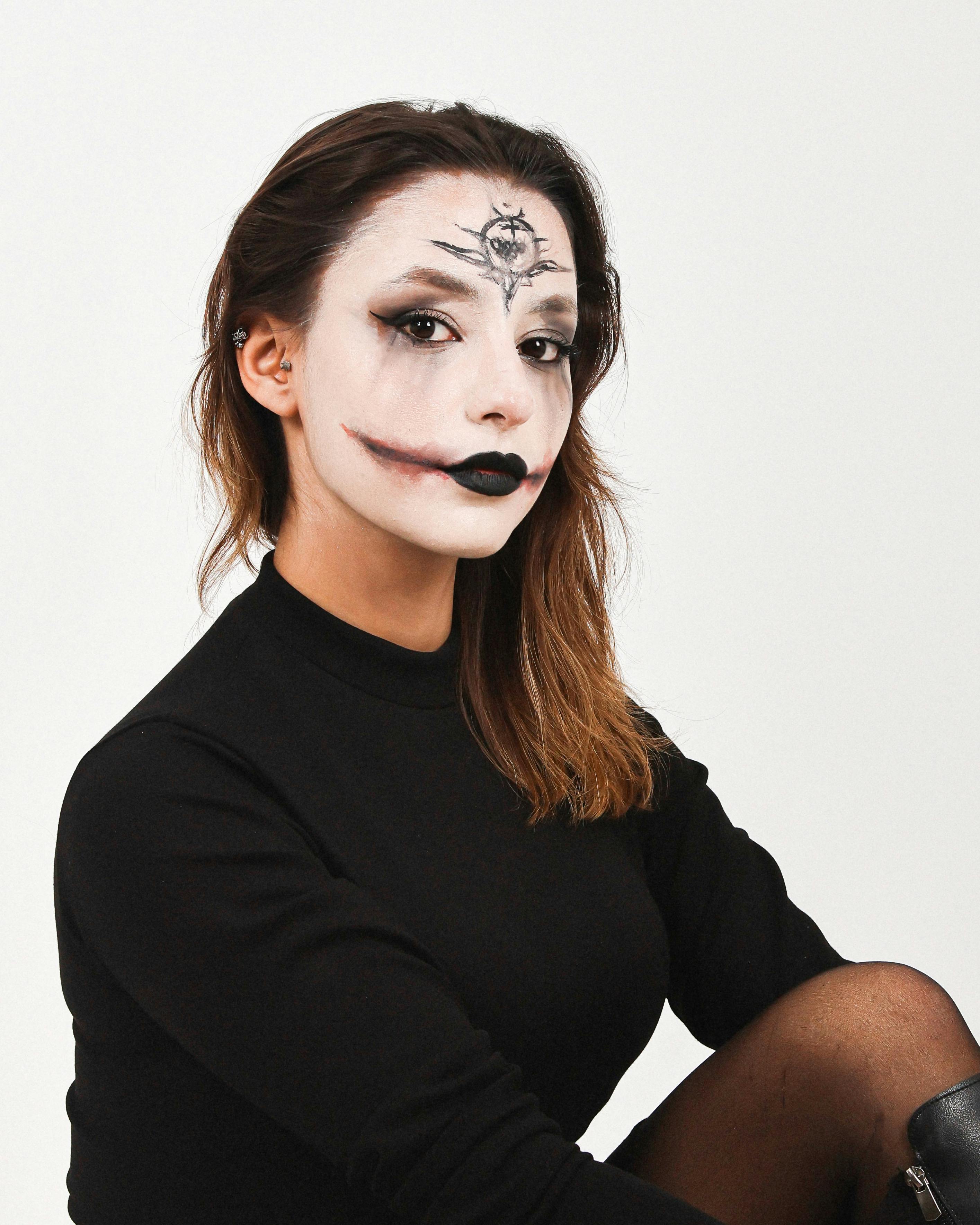 De franc Retrat impactant d'una dona amb maquillatge artístic de Halloween sobre un fons blanc net. Foto d'estoc