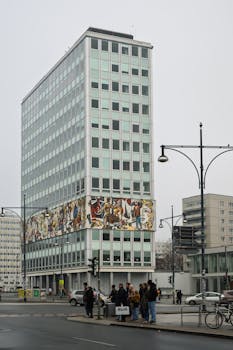 Modern highrise building featuring Berlin Wall mural in Berlin, Germany.