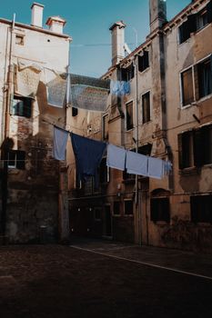 Narrow street with shabby walls of aged apartment buildings with clothes drying on ropes