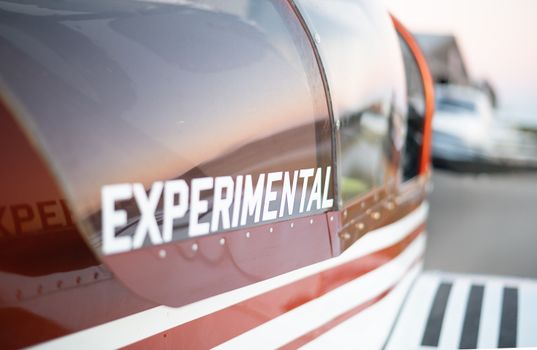 Detail view of an experimental aircraft wing with sunset reflections, emphasizing aeronautical innovation.