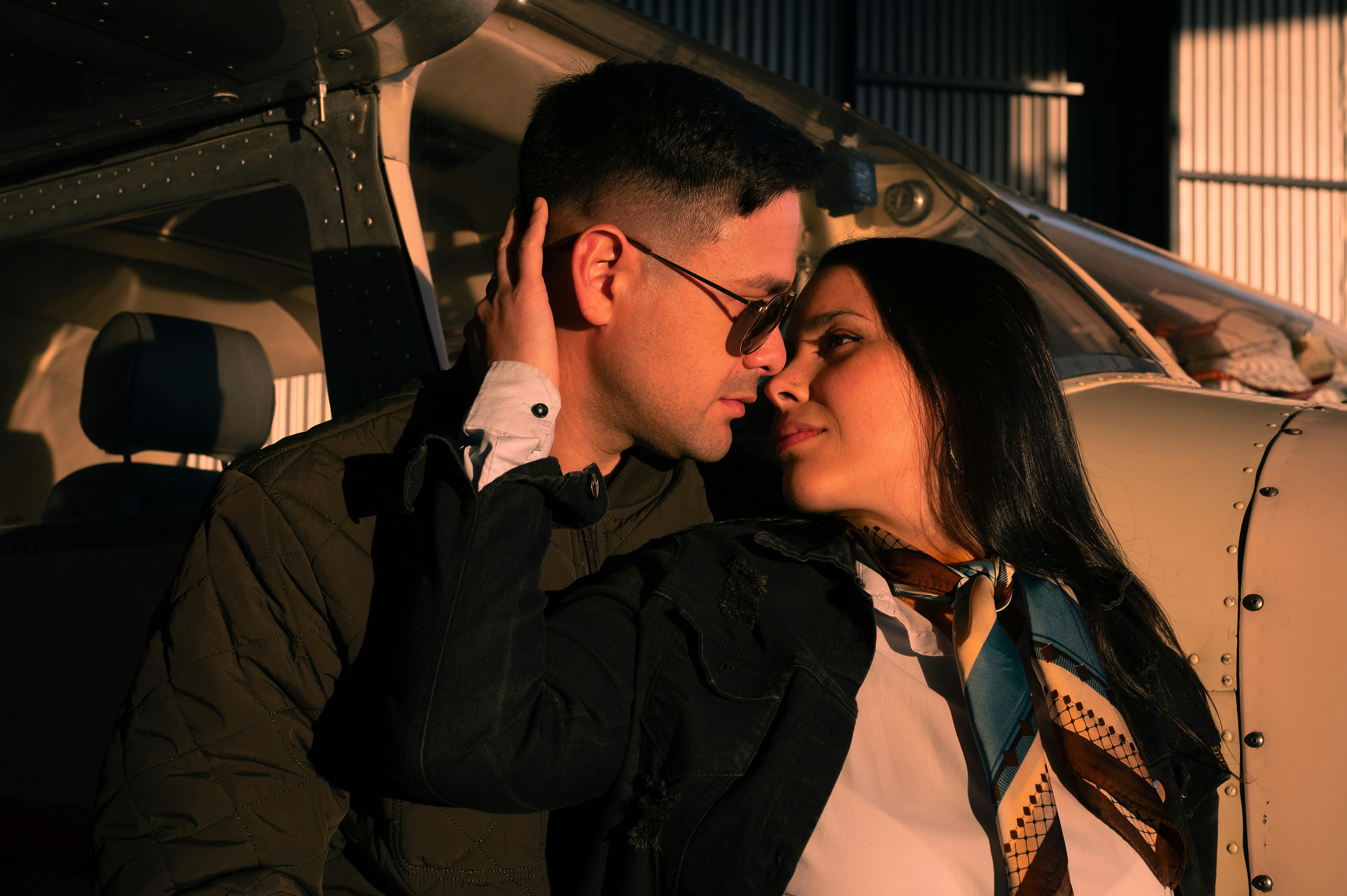 Zadarmo Pár sa dôverne spája súkromným lietadlom v slnečnom hangári. Fotka z fotobanky