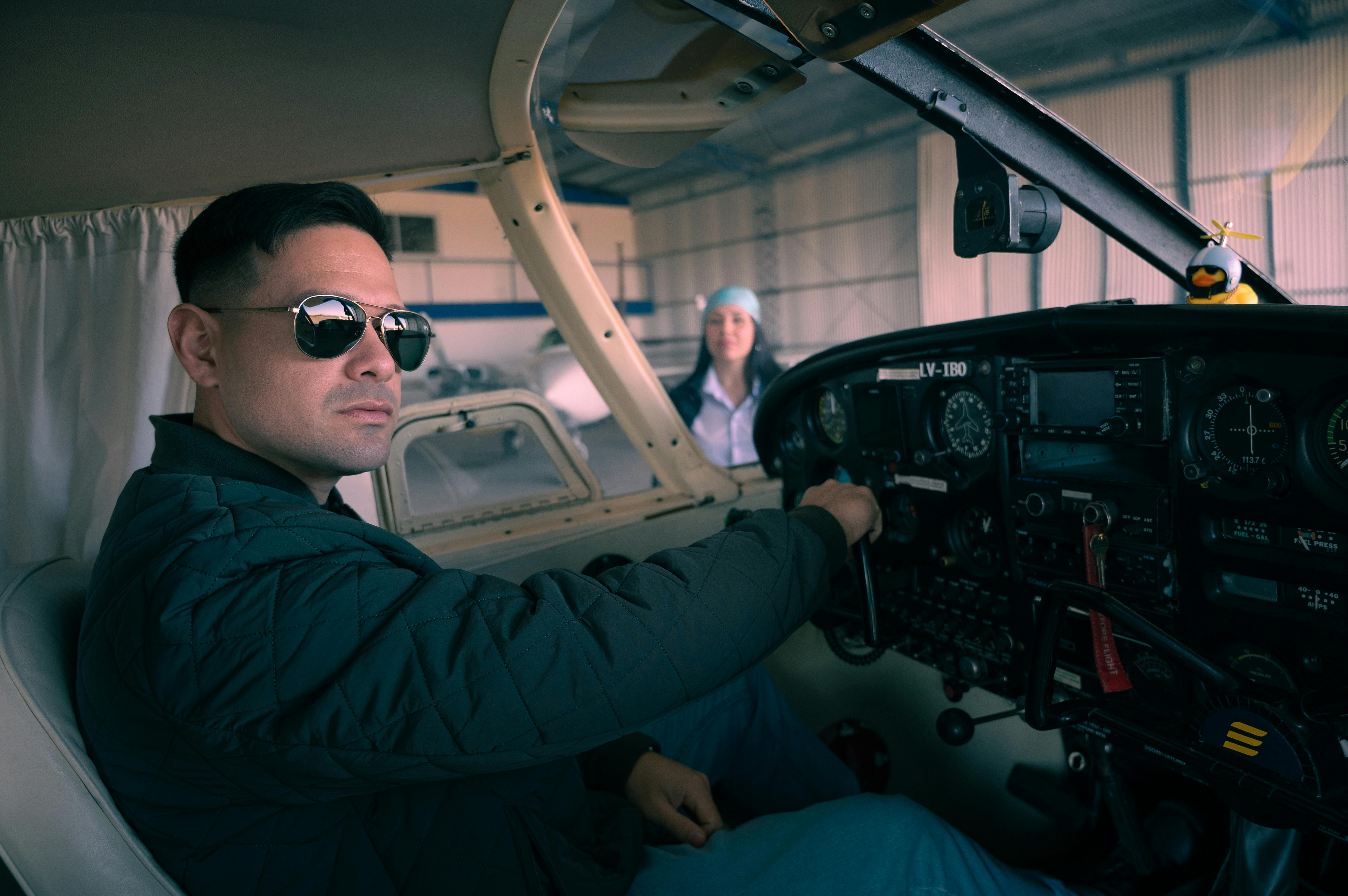 Zadarmo Sebavedomý pilot sediaci v kokpite lietadla a pripravujúci sa na vzlet v hangári. Fotka z fotobanky