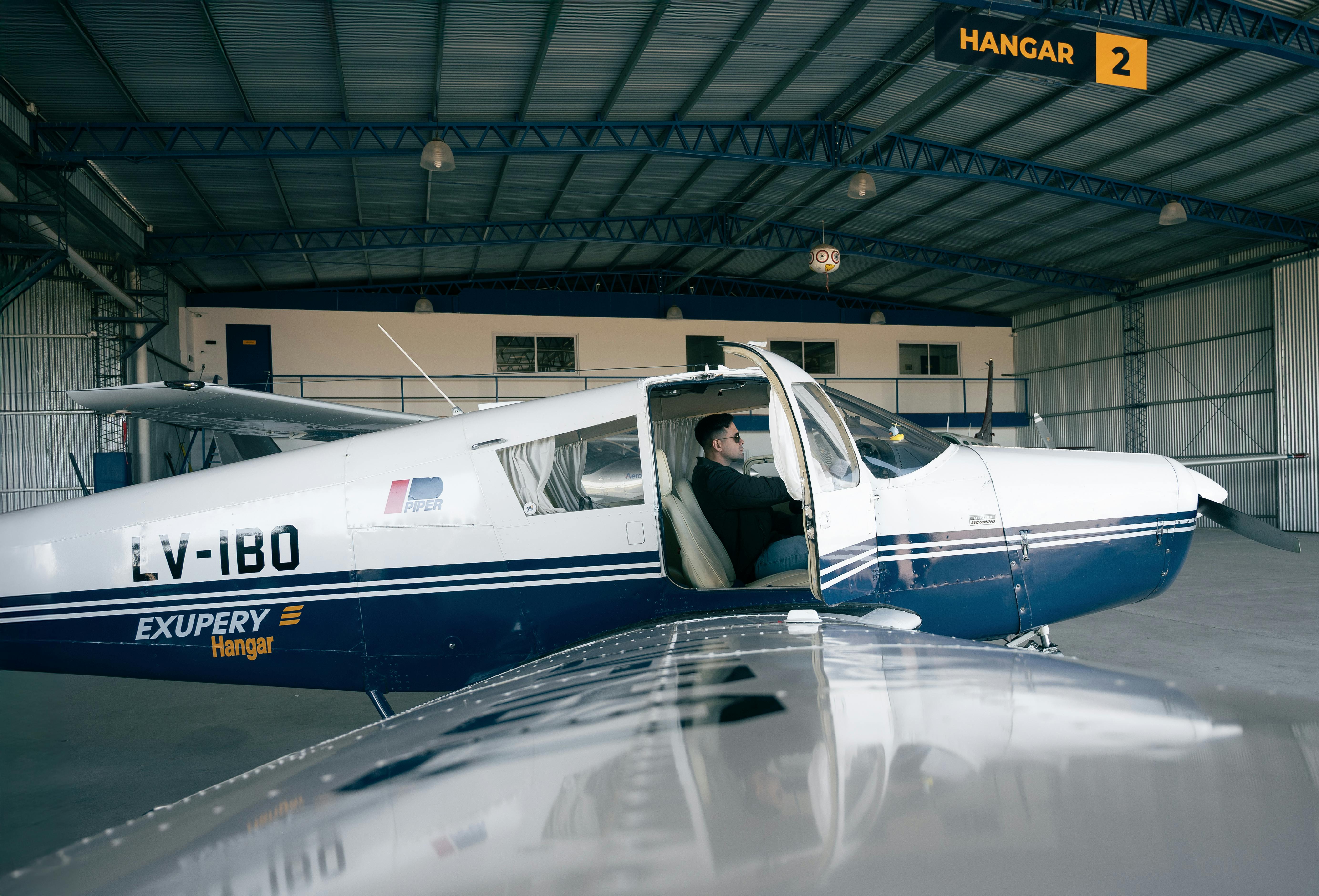 Zadarmo Malé lietadlo zaparkované v hangári s pilotom vo vnútri, letecká téma. Fotka z fotobanky