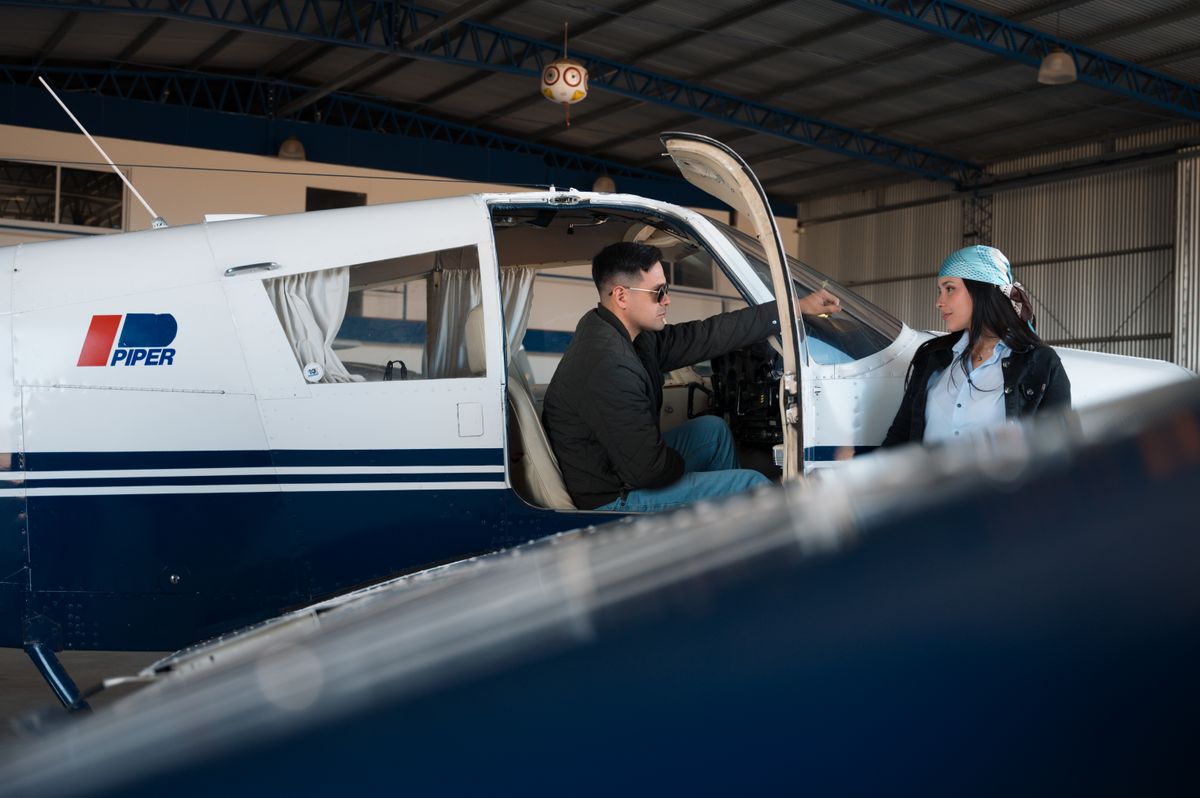 two pilots standing in front of shared GA aircraft in hangar