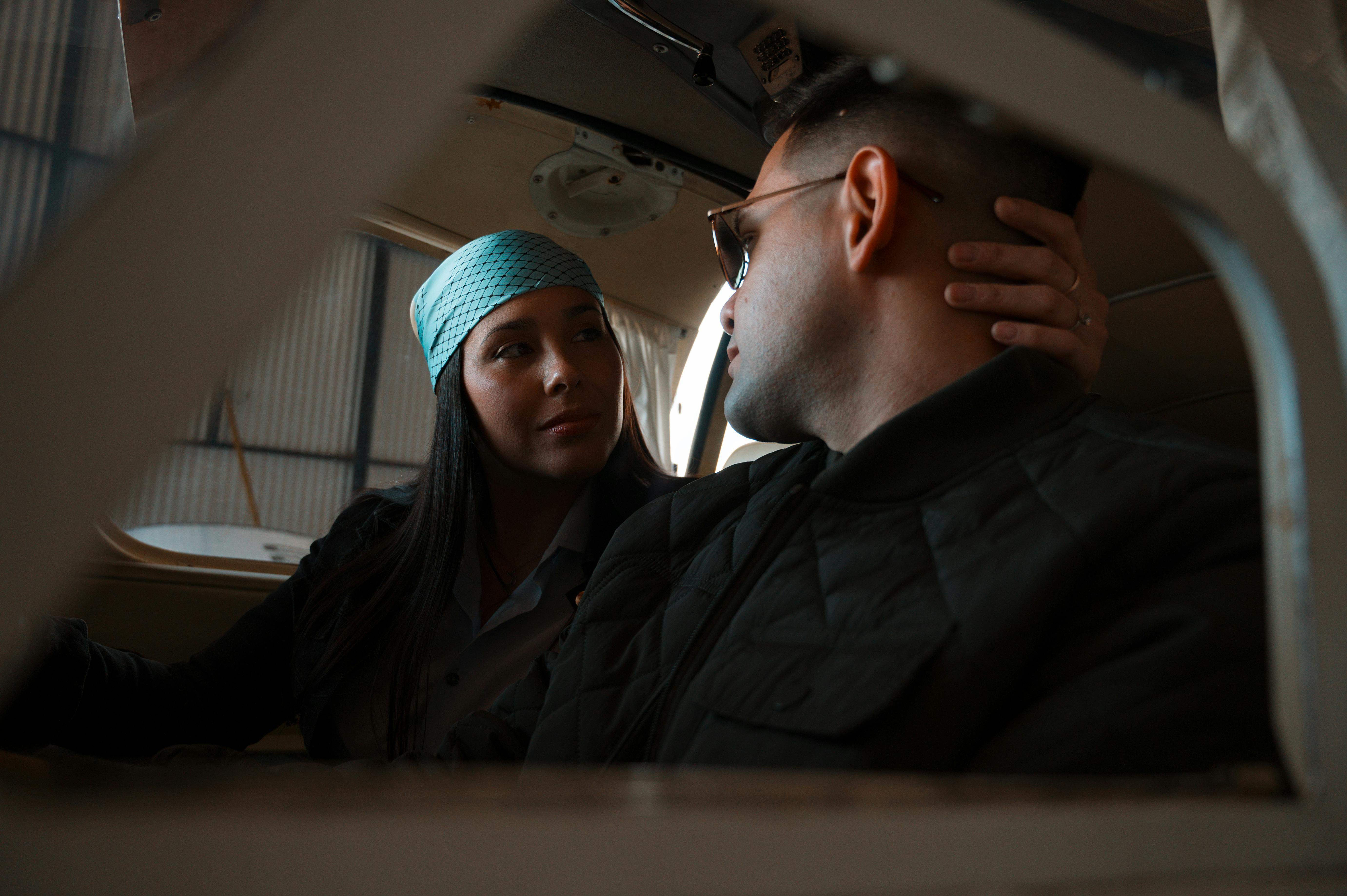 A couple in an airplane cockpit sharing a moment, with a romantic and adventurous vibe.