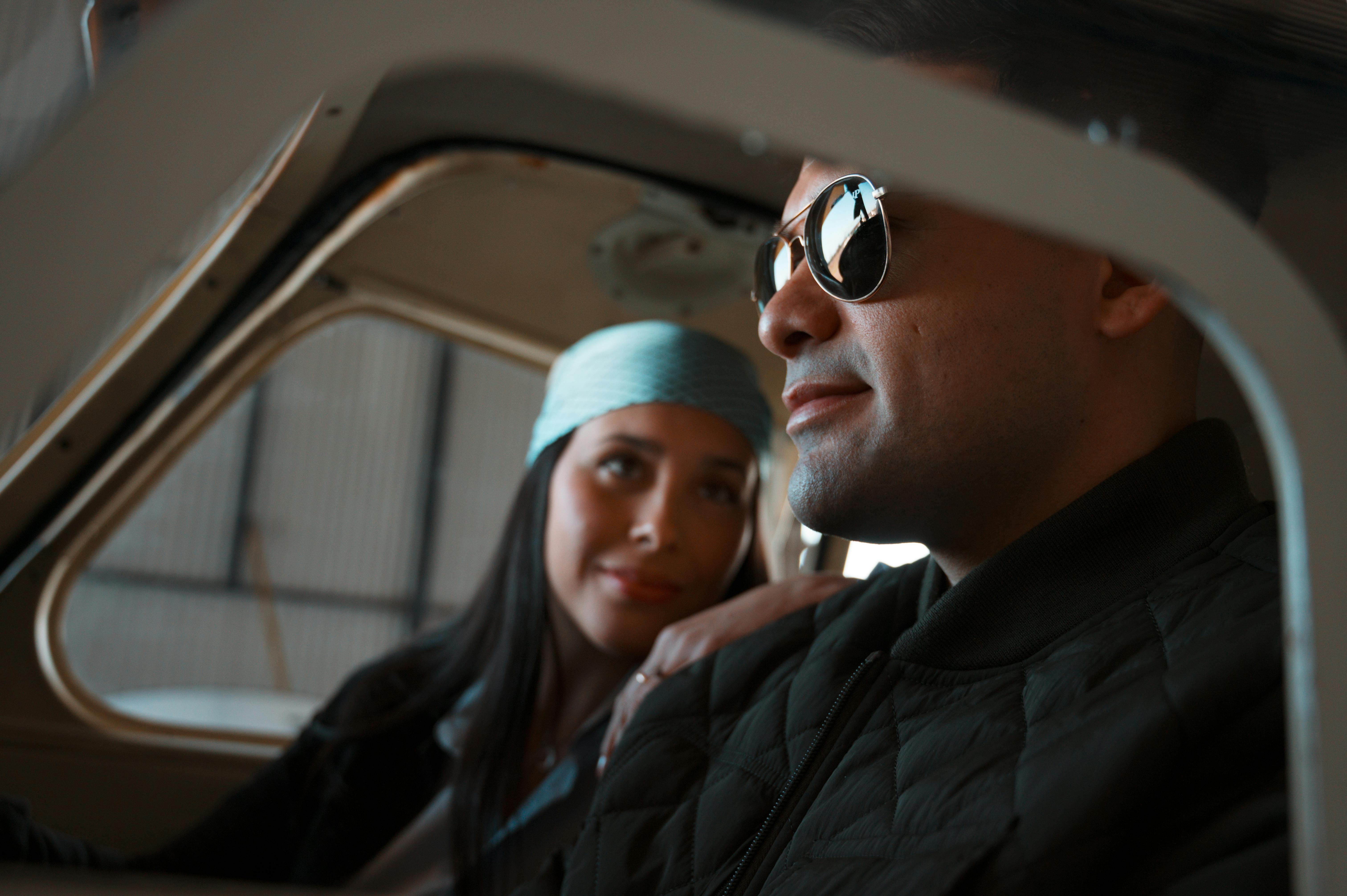 A couple enjoys a relaxed moment inside an airplane cockpit, showcasing travel and adventure themes.