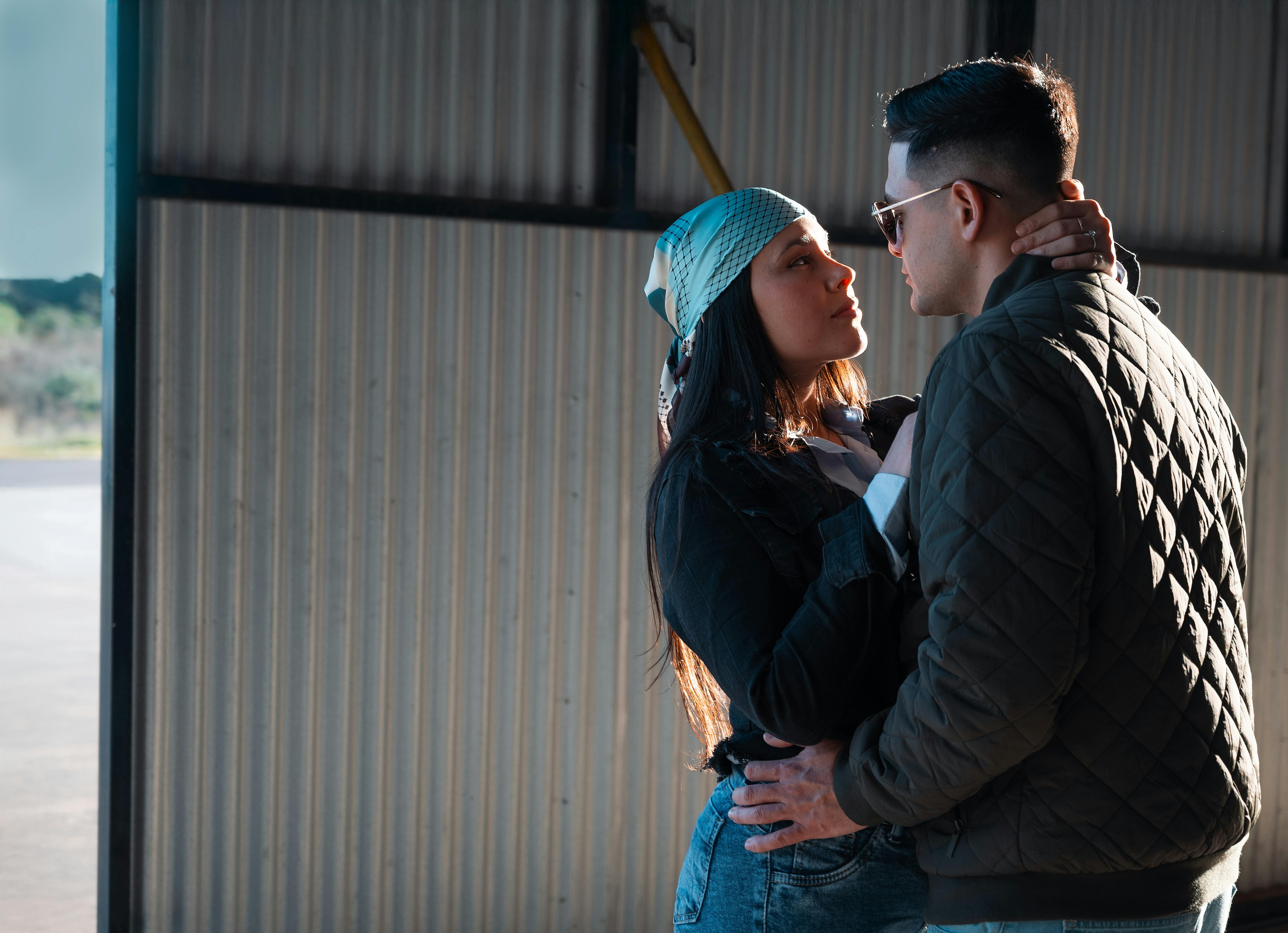 De franc Un moment romàntic entre una parella jove a l'entrada d'un hangar assolellat. Foto d'estoc