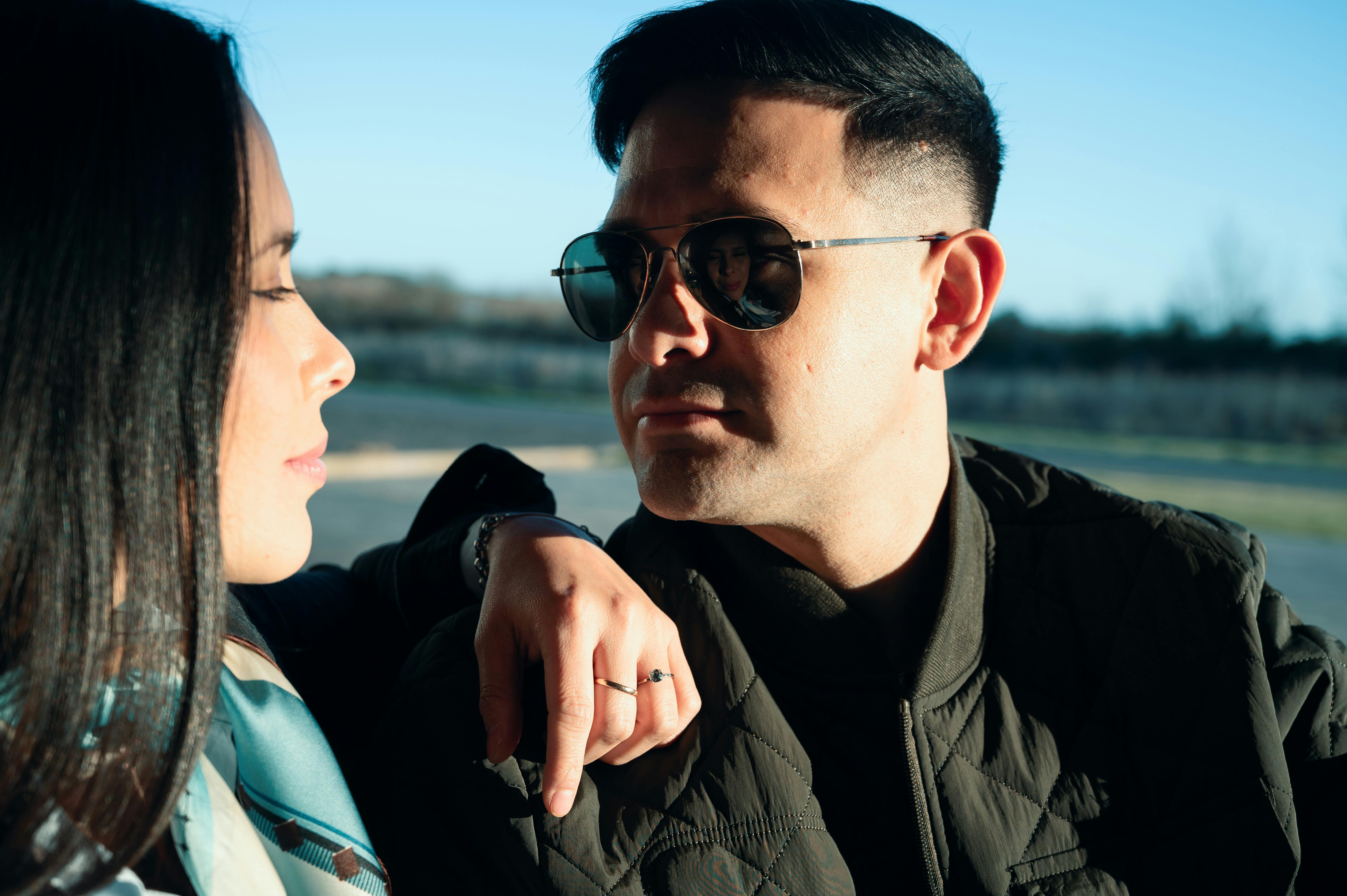 Zadarmo Módny pár, ktorý sa na seba pozerá pod slnkom a užíva si pokojný deň vonku. Fotka z fotobanky