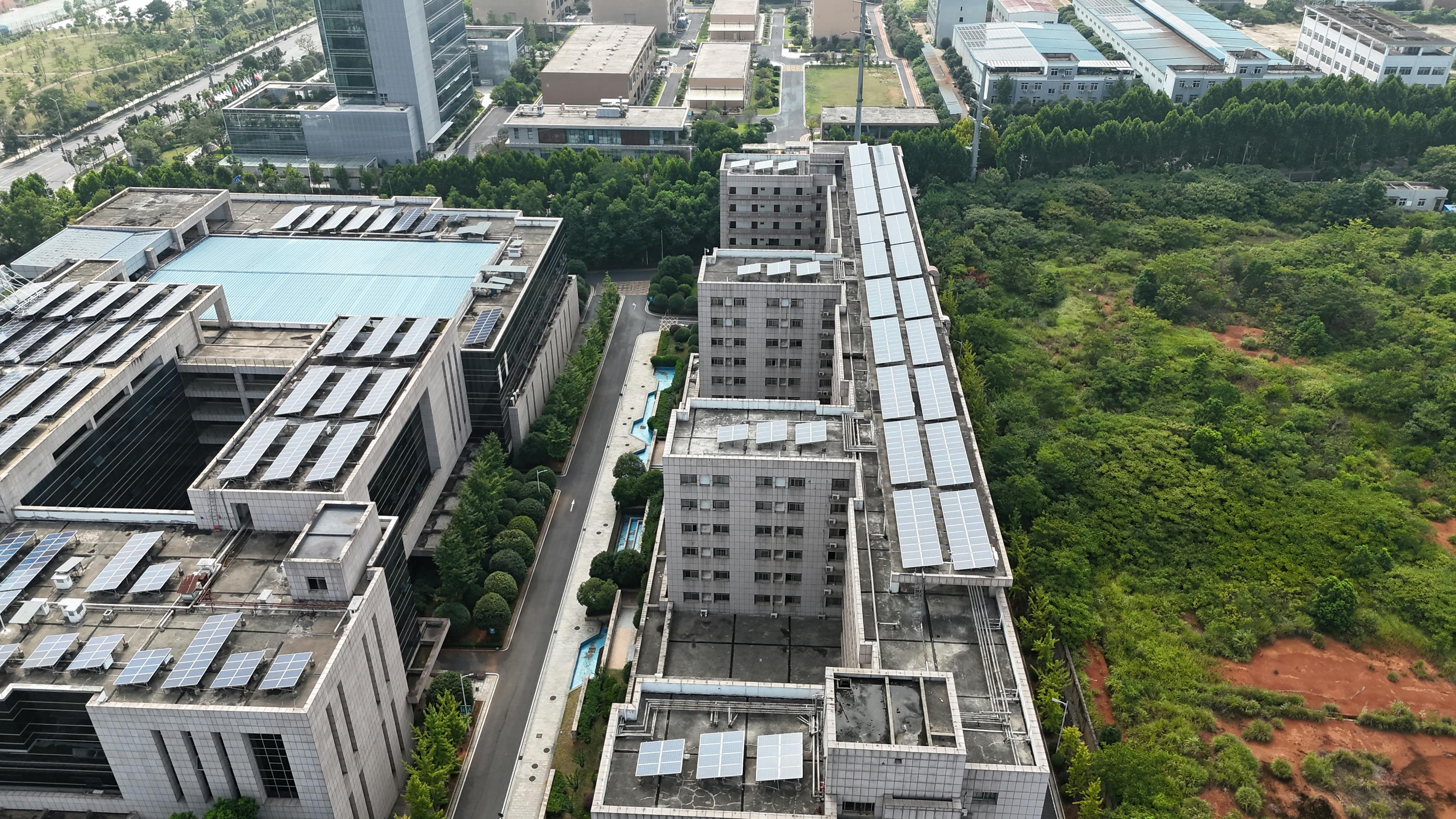 Gratis Paisaje urbano aéreo con tejados de paneles solares y espacios verdes. Foto de stock