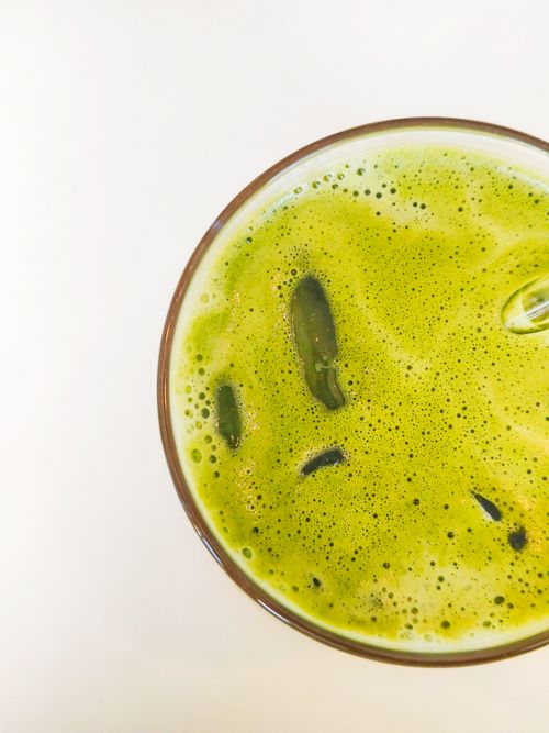 Free Top view of vibrant green iced matcha tea in a clear glass on a white background. Stock Photo