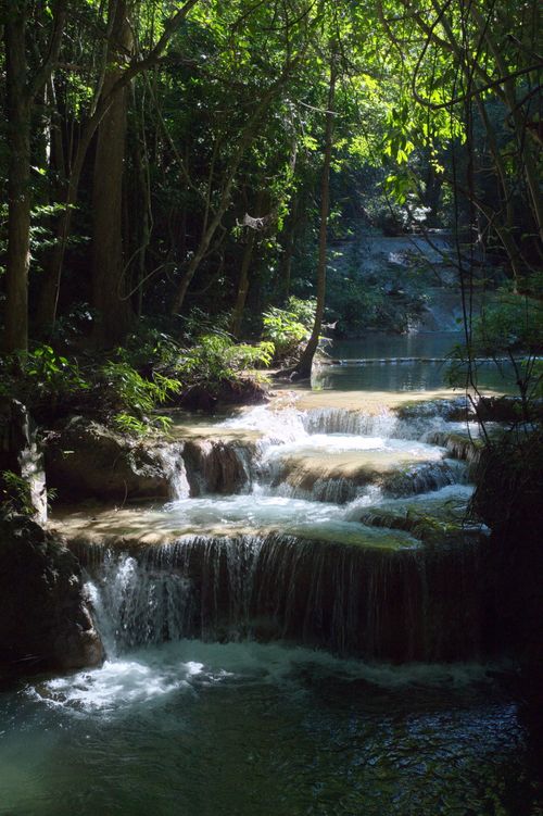 Free Serene cascading waterfall in lush forest at Tha Kradan, Kanchanaburi, Thailand. Stock Photo