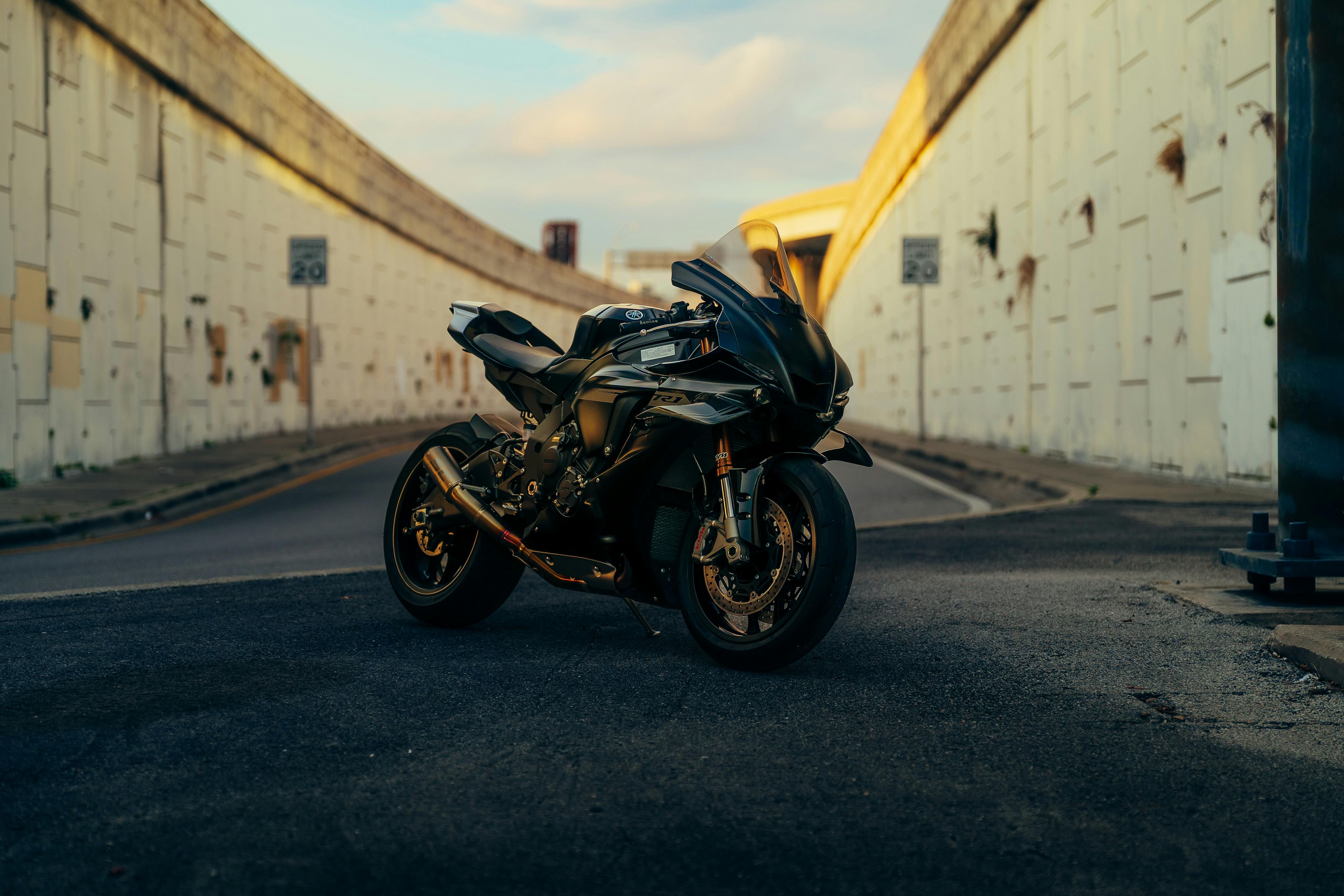 Kostenlos Ein imposantes schwarzes Motorrad parkt in einer stimmungsvoll beleuchteten Stadtstraße. Stock-Foto