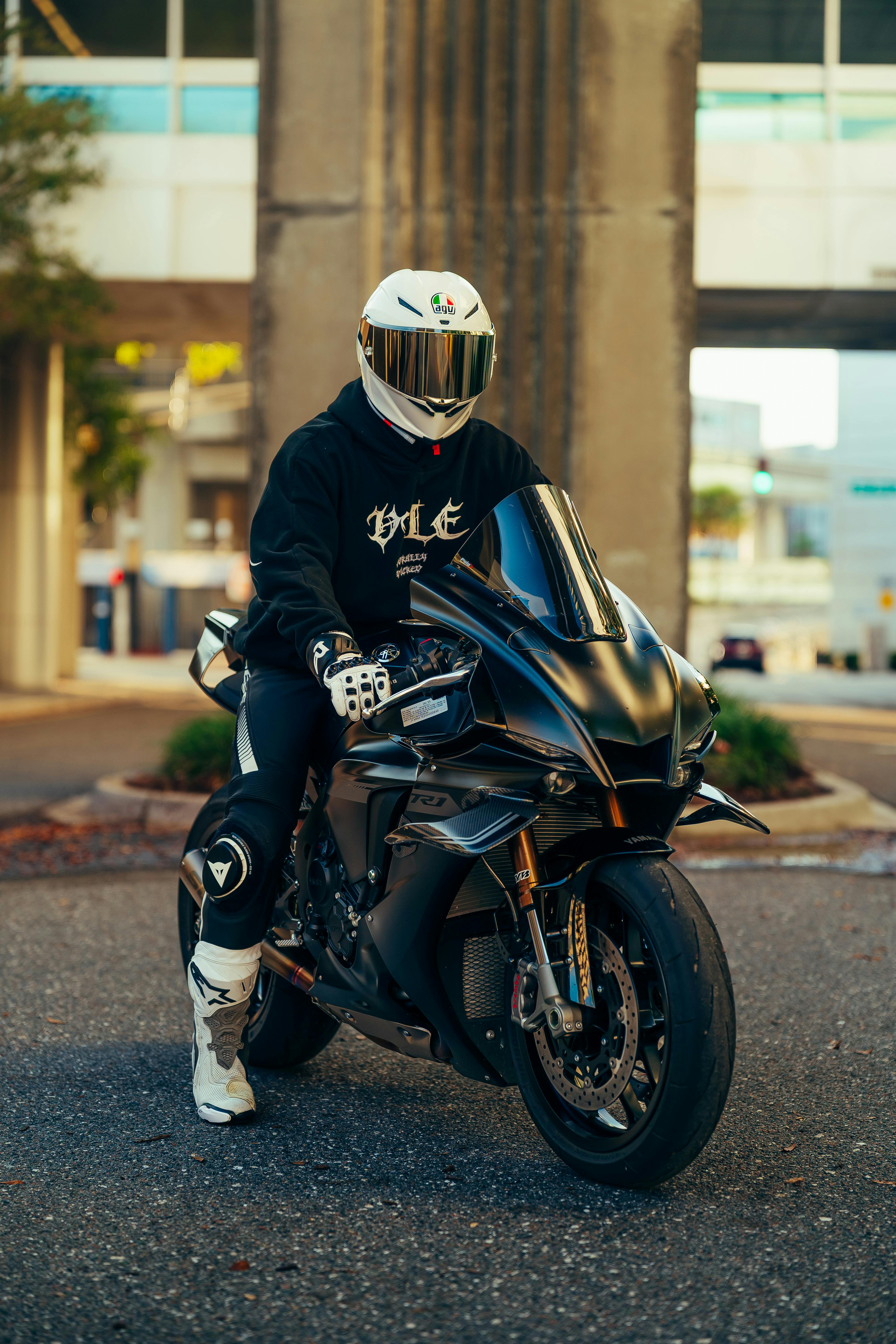 Kostenlos Person auf einem eleganten schwarzen Sportmotorrad im Stadtverkehr. Stock-Foto