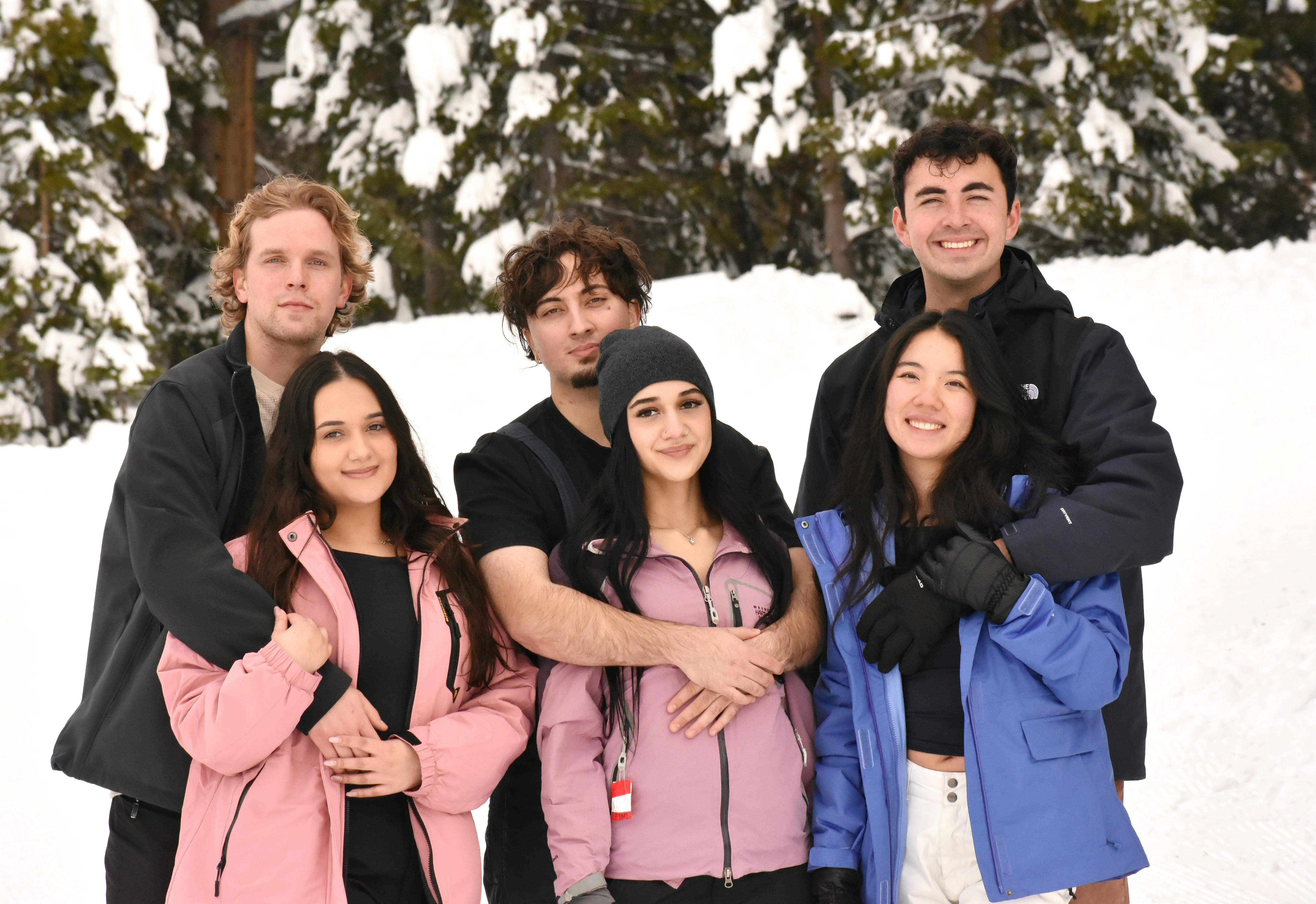 De franc Un grup d'amics alegres posant en un paisatge hivernal nevat. Foto d'estoc