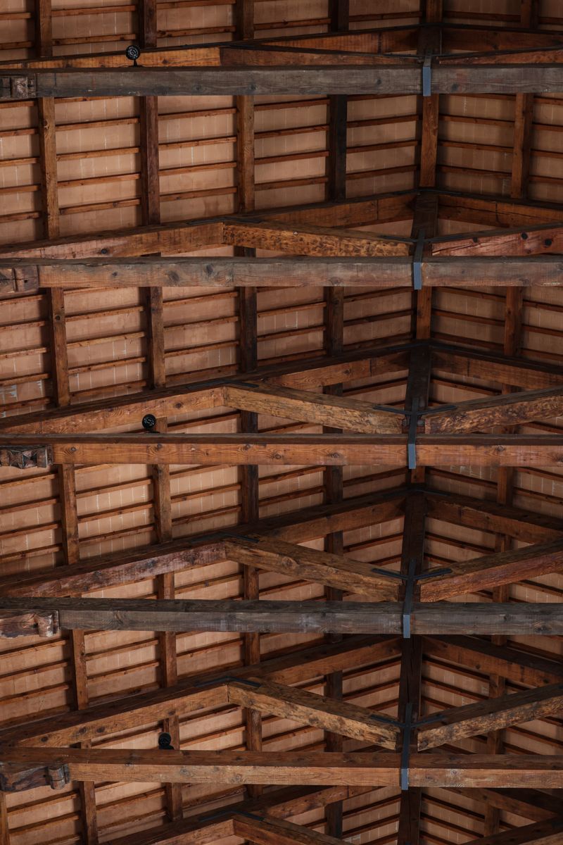 Detailed view of a rustic wooden ceiling with exposed beams, highlighting natural textures.